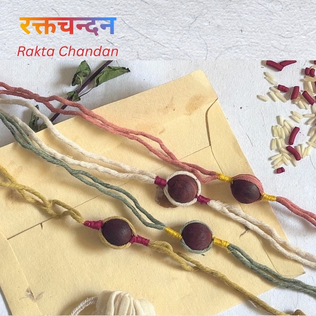 Plastic Free Rakhi handcrafted with naturally dyed organic cotton threads and red sandalwood beads. Includes cotton potli, Tilak, Akshat and handmade recycled cotton rag envelope.