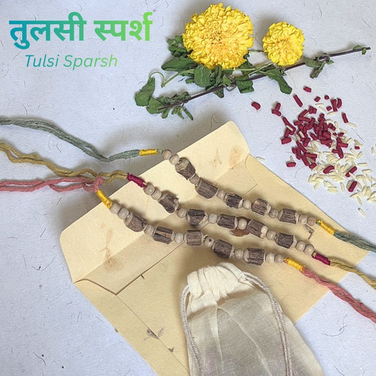 Tulsi Rakhi handcrafted with naturally dyed organic cotton threads and sacred Tulsi beads. Includes cotton potli, Tilak, Akshat and a handmade recycled cotton rag envelope.