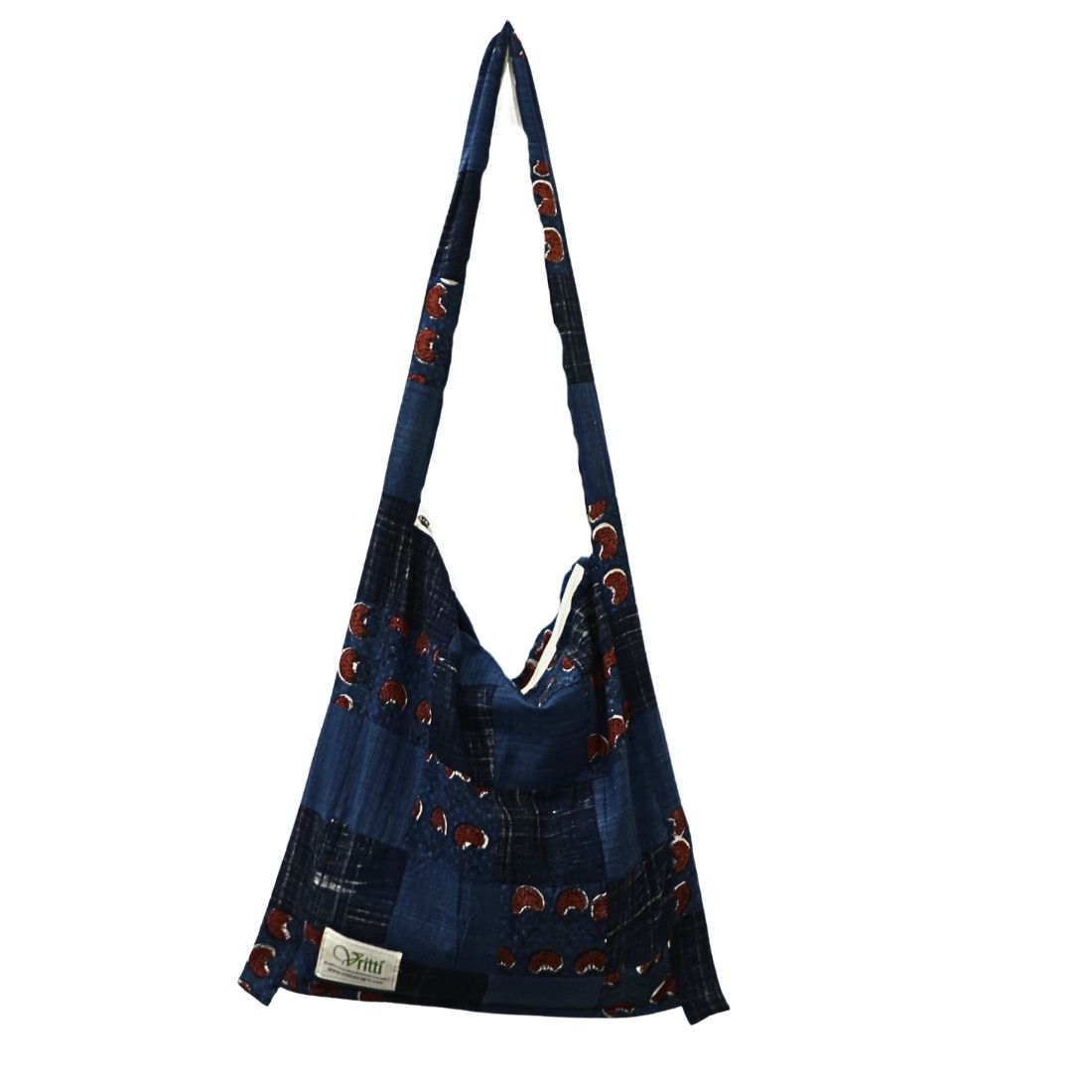 This indigo printed shoulder bag celebrates traditional patchwork craftsmanship, pieced together from small square patches of printed cotton fabric in rich indigo blue. Each patch tells a story of handmade artistry, creating a one-of-a-kind textile composition.