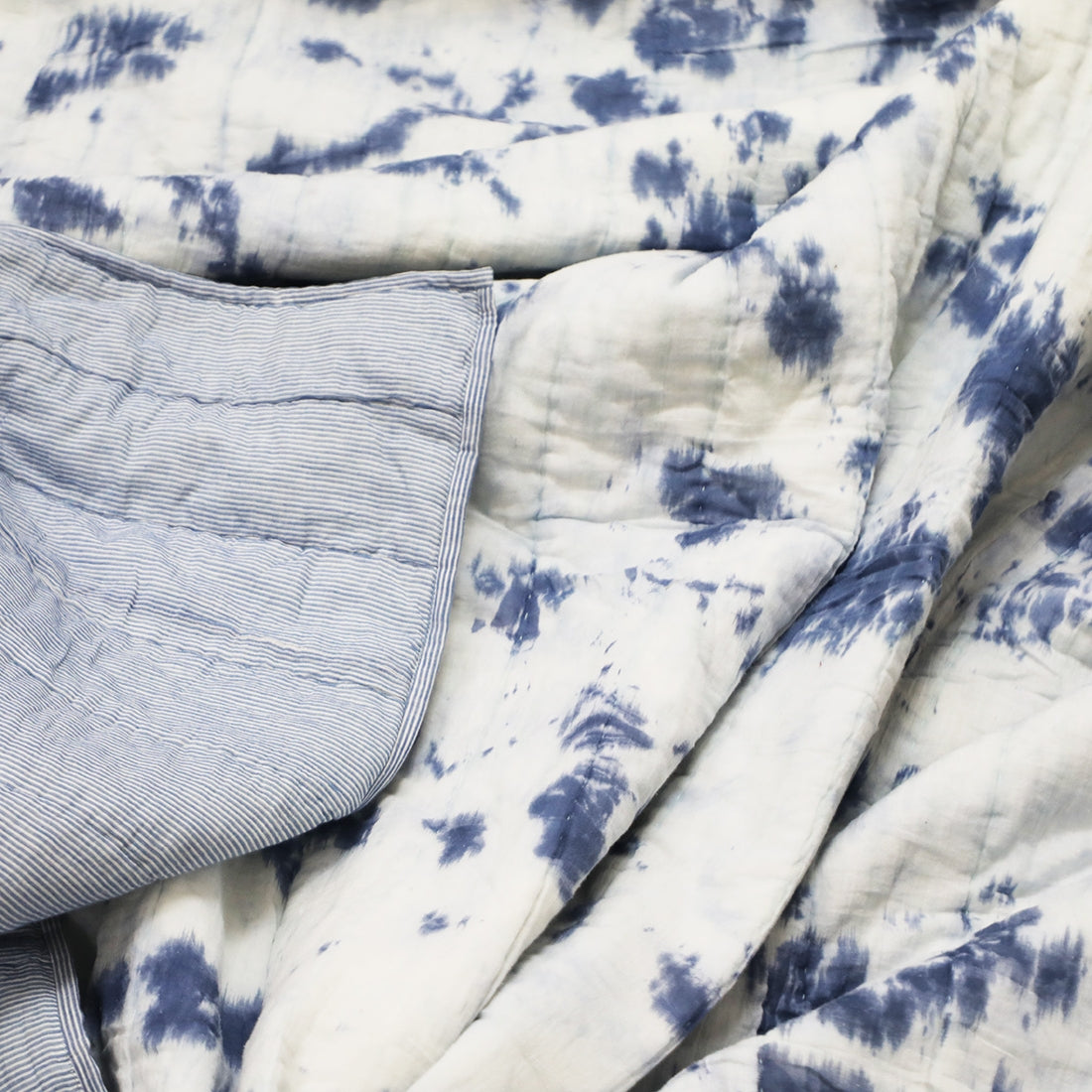 indigo tie & dye cotton quilt styled on bed
