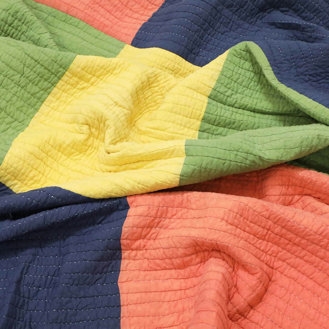 colour block cotton patchwork quilt styled on bed
