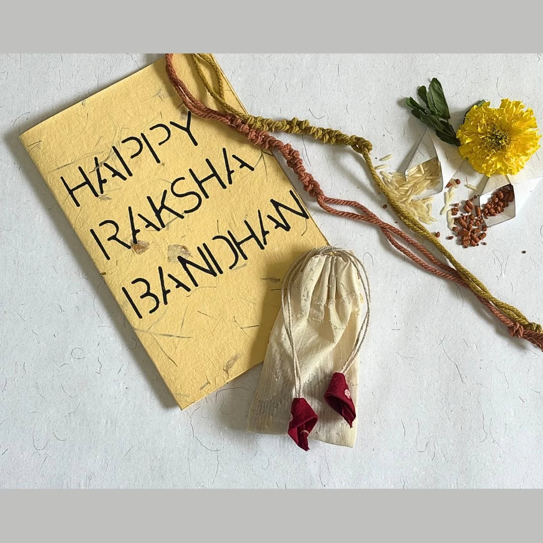 Eco-friendly organic rakhi set of 2 handcrafted with natural dyed cotton threads in Madder Red and Yellow. Comes in cotton potli with recycled card. Made in India.