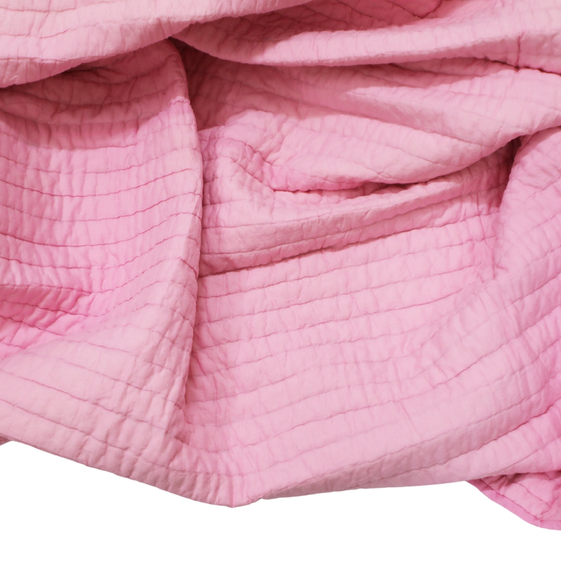 pink & white kantha cotton quilt styled on bed
